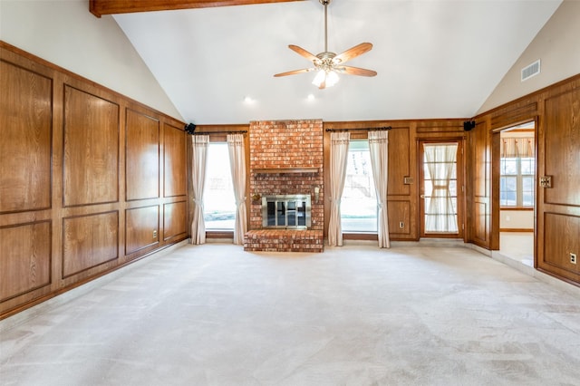 unfurnished living room with a brick fireplace, light colored carpet, lofted ceiling, and ceiling fan