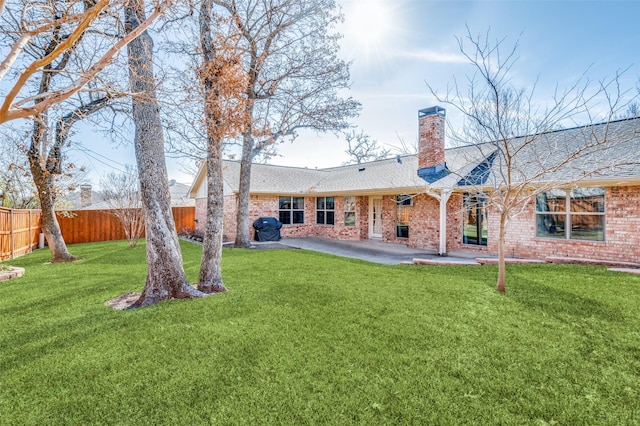 rear view of house featuring a yard and a patio