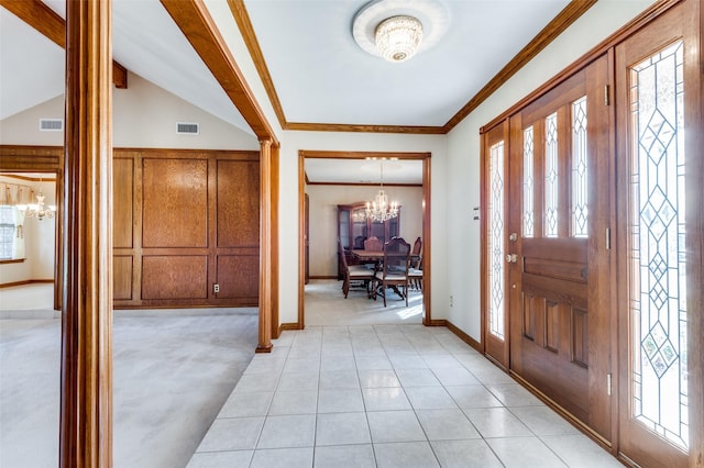 carpeted entryway with crown molding, vaulted ceiling, and an inviting chandelier