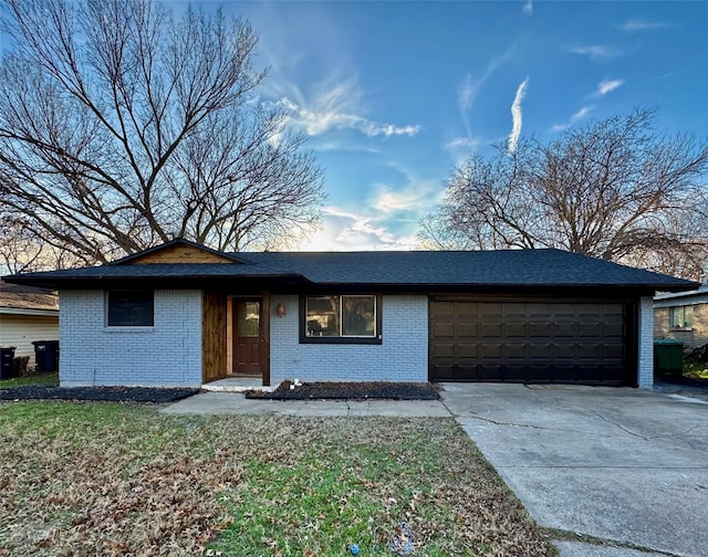 ranch-style house featuring concrete driveway, brick siding, and an attached garage