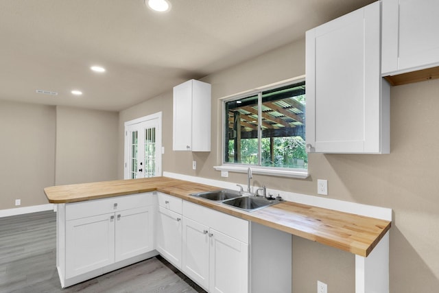 3482 Bandera Rd, Fort Worth, TX 76116 - kitchen featuring wood counters, a sink, a peninsula, recessed lighting, and light wood-type flooring