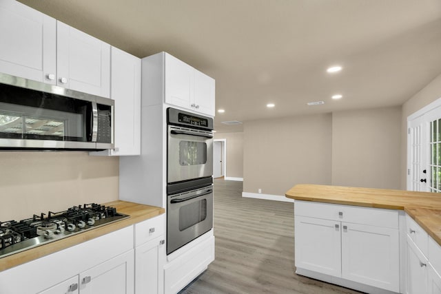 3482 Bandera Rd, Fort Worth, TX 76116 - kitchen featuring appliances with stainless steel finishes, wooden counters, recessed lighting, light wood-style floors, and white cabinetry