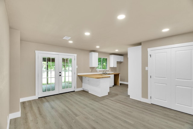 3482 Bandera Rd, Fort Worth, TX 76116 - kitchen featuring wood counters, a peninsula, white cabinets, french doors, and light wood-style flooring