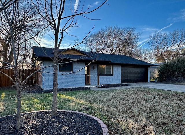 ranch-style home featuring brick siding, fence, a garage, driveway, and a front lawn