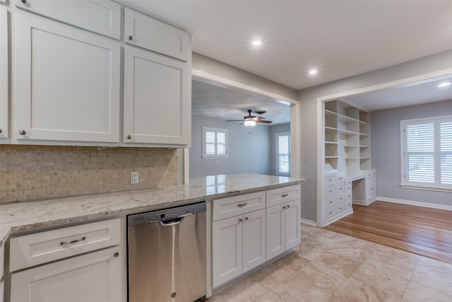 kitchen featuring light stone countertops, white cabinets, backsplash, and stainless steel dishwasher