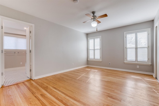 empty room featuring ceiling fan, a wealth of natural light, and light hardwood / wood-style flooring