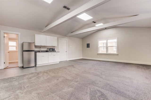 unfurnished living room featuring light carpet, lofted ceiling with beams, sink, and electric panel