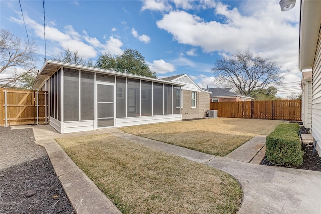 back of property with a sunroom and a lawn