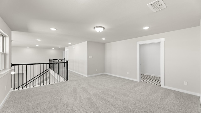 spare room featuring light carpet, baseboards, visible vents, and recessed lighting