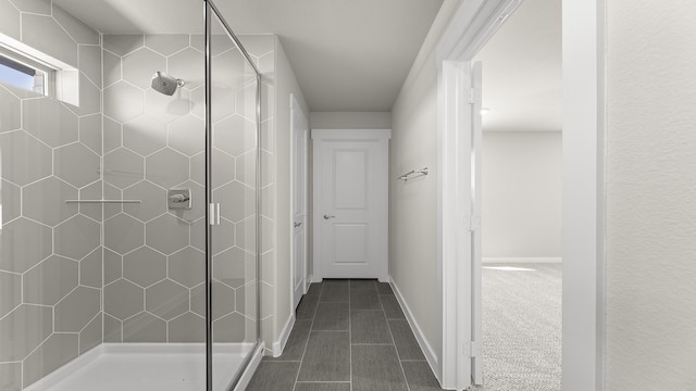 bathroom featuring a shower stall, baseboards, and tile patterned flooring