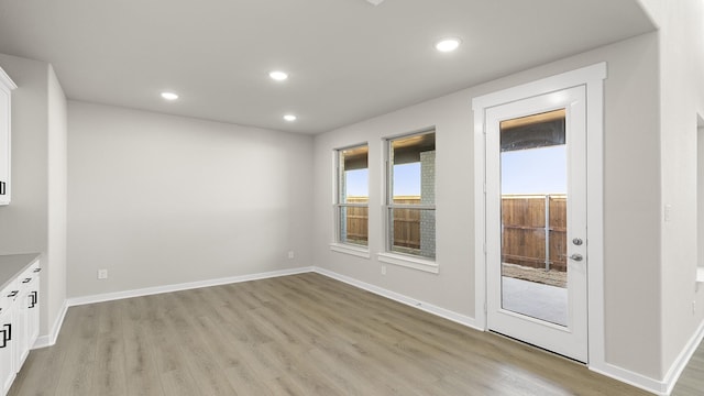 spare room featuring baseboards, light wood-style flooring, and recessed lighting