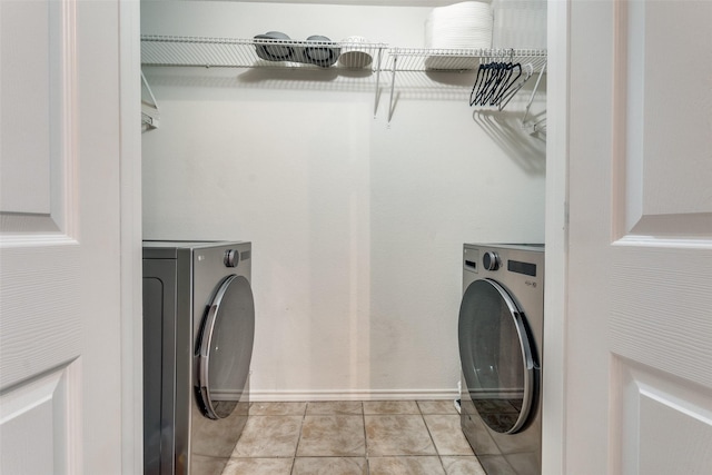 laundry area with light tile patterned floors and washer / clothes dryer