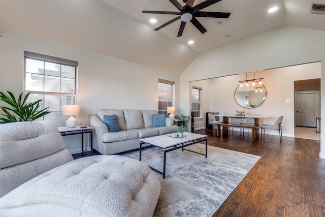 living room with ceiling fan, dark hardwood / wood-style flooring, and vaulted ceiling