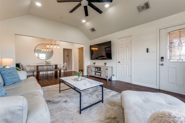 living room with vaulted ceiling, ceiling fan with notable chandelier, and hardwood / wood-style flooring