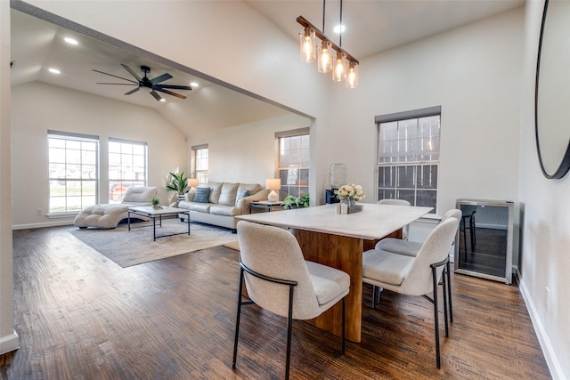 dining room with ceiling fan, dark hardwood / wood-style flooring, and a towering ceiling