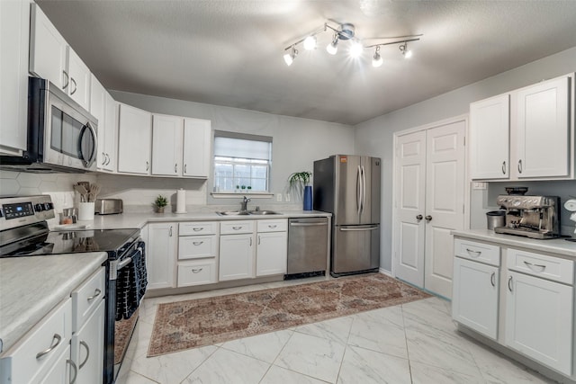 kitchen featuring sink, a textured ceiling, white cabinets, and stainless steel appliances