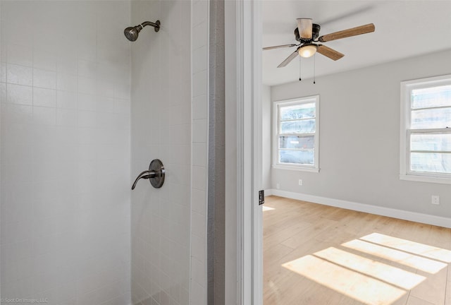 bathroom with hardwood / wood-style flooring, walk in shower, and ceiling fan