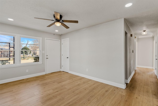 unfurnished room with a textured ceiling, light hardwood / wood-style flooring, and ceiling fan