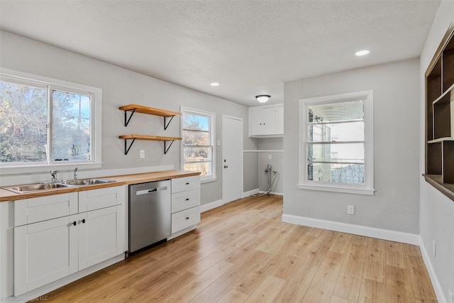 kitchen featuring dishwasher, white cabinetry, light hardwood / wood-style floors, sink, and butcher block countertops