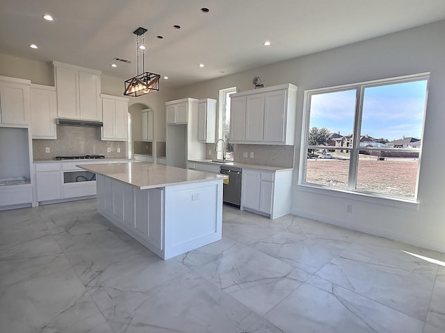 kitchen with white cabinetry, a center island, hanging light fixtures, stainless steel dishwasher, and sink