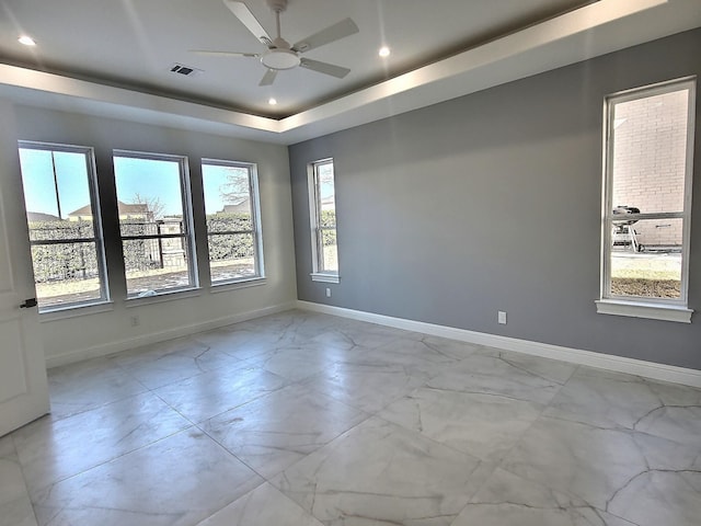 unfurnished room featuring ceiling fan and a tray ceiling