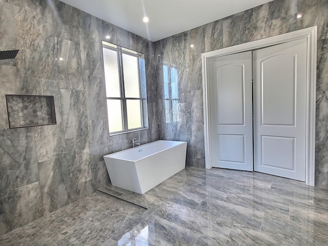 bathroom featuring a bathing tub and tile walls