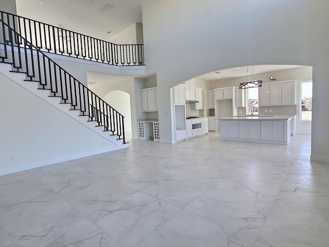 unfurnished living room with a high ceiling and sink