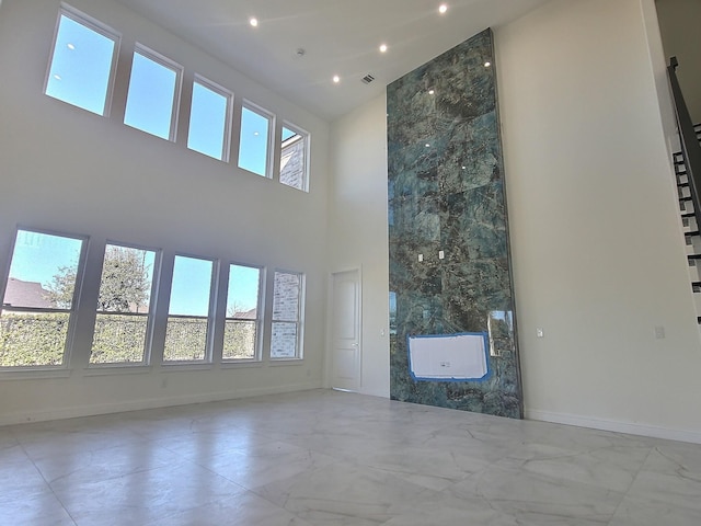 unfurnished living room featuring a high ceiling