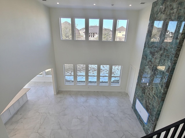 unfurnished living room featuring a towering ceiling