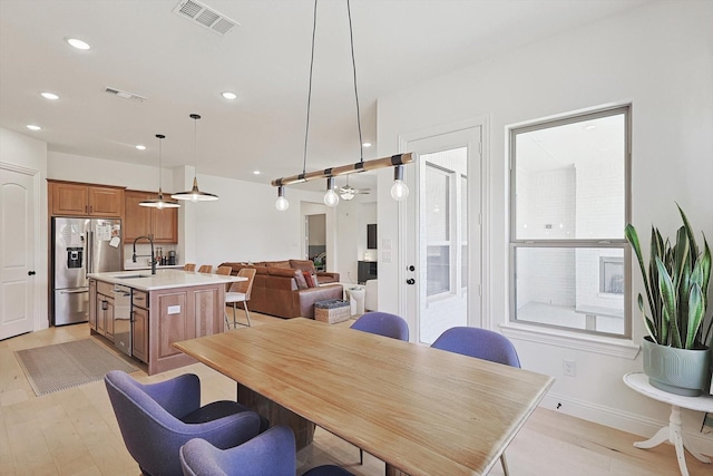 dining room with sink and light hardwood / wood-style floors