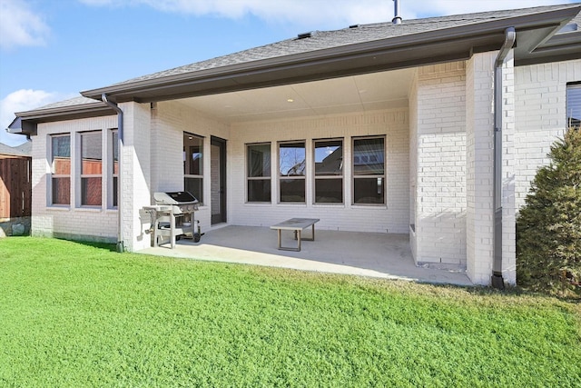 back of property with a patio area and a lawn