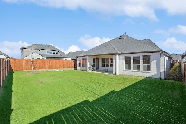 rear view of house featuring a yard and a patio area