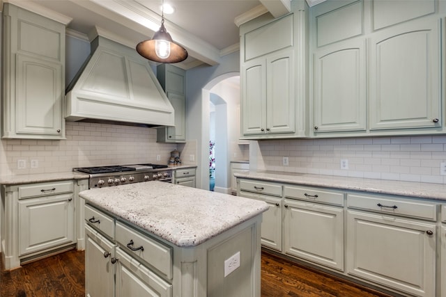 kitchen with tasteful backsplash, hanging light fixtures, ornamental molding, custom range hood, and dark hardwood / wood-style flooring