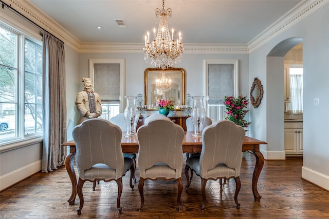 dining space featuring dark wood-type flooring, plenty of natural light, ornamental molding, and a notable chandelier