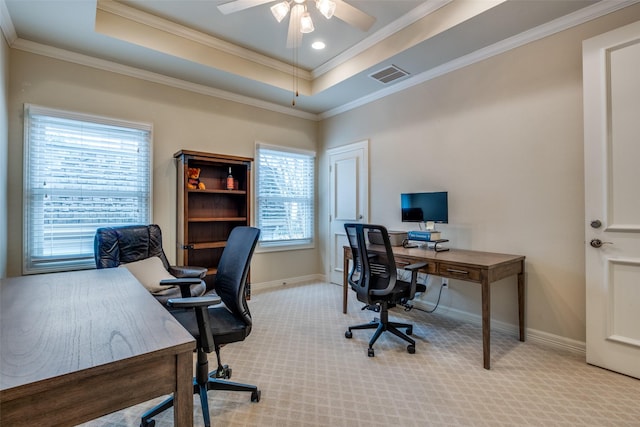 carpeted home office with ceiling fan, crown molding, and a raised ceiling