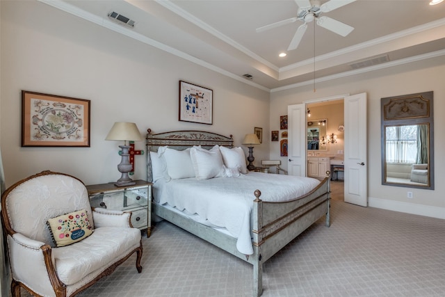 bedroom with light carpet, ceiling fan, a raised ceiling, ensuite bath, and ornamental molding