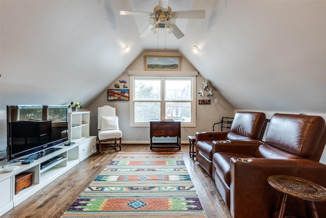 living room featuring ceiling fan, wood-type flooring, and vaulted ceiling