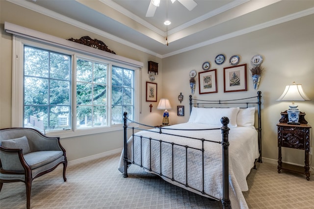 bedroom featuring ceiling fan, light colored carpet, a tray ceiling, and ornamental molding