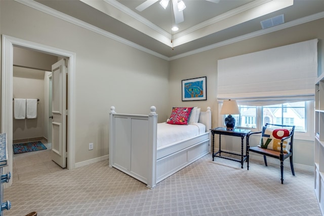 carpeted bedroom featuring ceiling fan, a tray ceiling, and ornamental molding