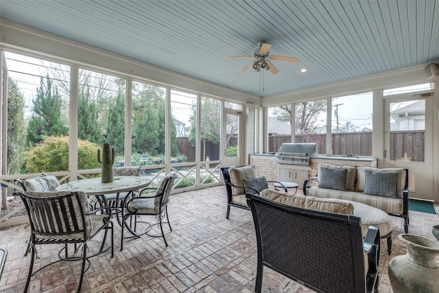 sunroom featuring ceiling fan