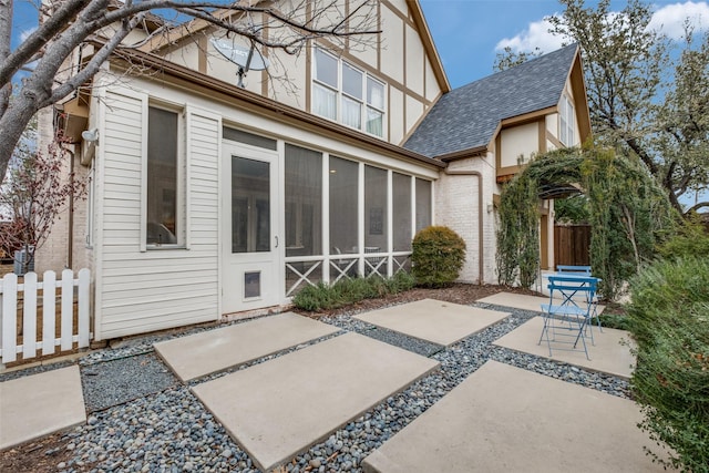 rear view of property with a patio area and a sunroom