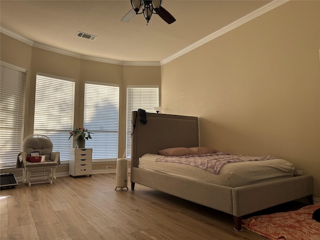 bedroom with ceiling fan, crown molding, and light wood-type flooring