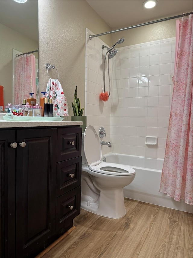 full bathroom with toilet, shower / tub combo, hardwood / wood-style flooring, and vanity