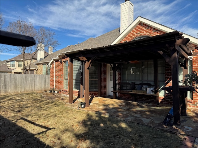 back of house with a lawn and a patio