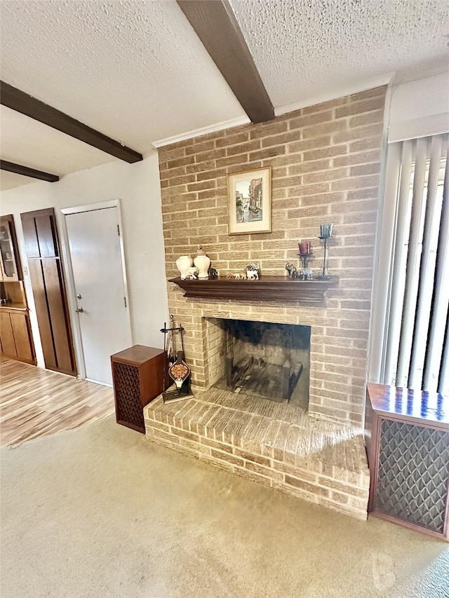 carpeted living room featuring a brick fireplace, a textured ceiling, and beamed ceiling