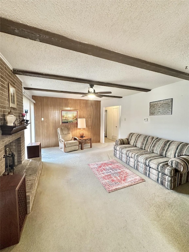 carpeted living room with beamed ceiling, wooden walls, and a textured ceiling