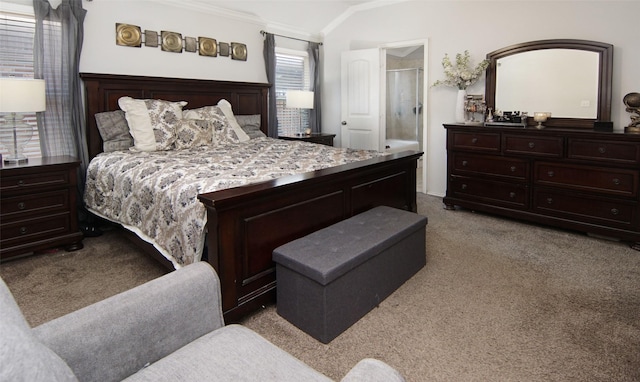 bedroom featuring light carpet, crown molding, ensuite bathroom, and lofted ceiling