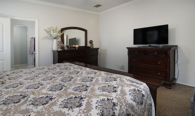 bedroom with ornamental molding and light colored carpet