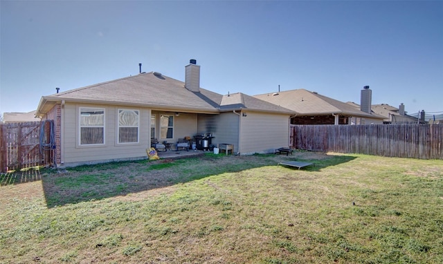 back of house featuring a lawn and a patio area