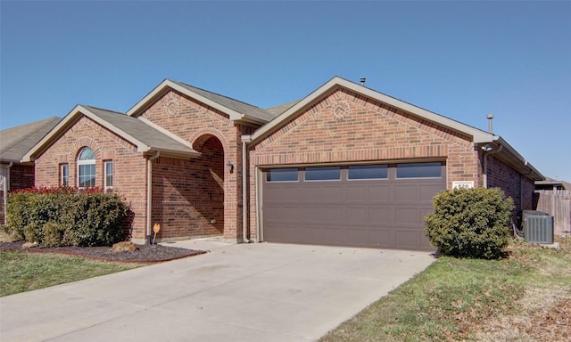 ranch-style house featuring a garage and cooling unit